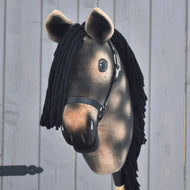 Hobby Horse Stormy s černou ohlávkou od Hobby Horse LarDen, realistický hannoverský hřebec v šedém grošování s černou přízovou hřívou a hnědou plyšovou hlavou na tyči, před světle šedou dřevěnou stěnou.