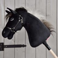 Hobby Horse Bond s černou ohlávkou od Hobby Horse LarDen, černý plyšový Hobby Horse s bílou hřívou, černou ohlávkou a otěžemi na dřevěné tyči, zobrazený před světlou dřevěnou stěnou – ideální pro každého fanouška Hobby Horse Bond.