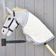 Hobby Horse LarDen se šedou plyšovou hlavou, černou uzdečkou a dekou Cream Pearl s modrým lemováním na dřevěné tyči, zobrazený před šedou dřevěnou stěnou.
