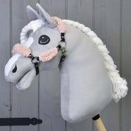 Černá ohlávka z koženky s kompletním starorůžovým beránkem od Hobby Horse LarDen na plyšovém Hobby Horse se světle šedou hlavou, bílou pletenou hřívou a černou ohlávkou, na dřevěné tyči před dřevěným panelovým pozadím.