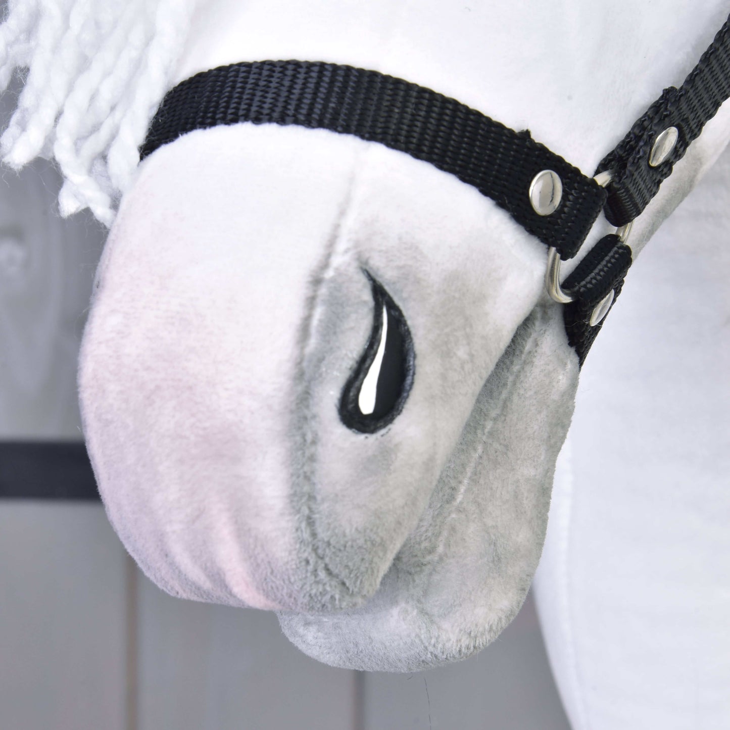 Detail Hobby Horse Elektra s černou ohlávkou od Hobby Horse LarDen s plyšovým bílým obličejem, černou ohlávkou, vyšívaným černým detailem ve tvaru slzy, jemnou texturou, bílou přízovou hřívou a rysy inspirovanými lipicánskou klisnou.