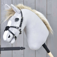 Mexický nánosník černý od Hobby Horse LarDen na šedém plyšovém Hobby Horse s černou uzdečkou, nánosníkem z koženky a světlou hřívou, na tyči před šedou dřevěnou stěnou.