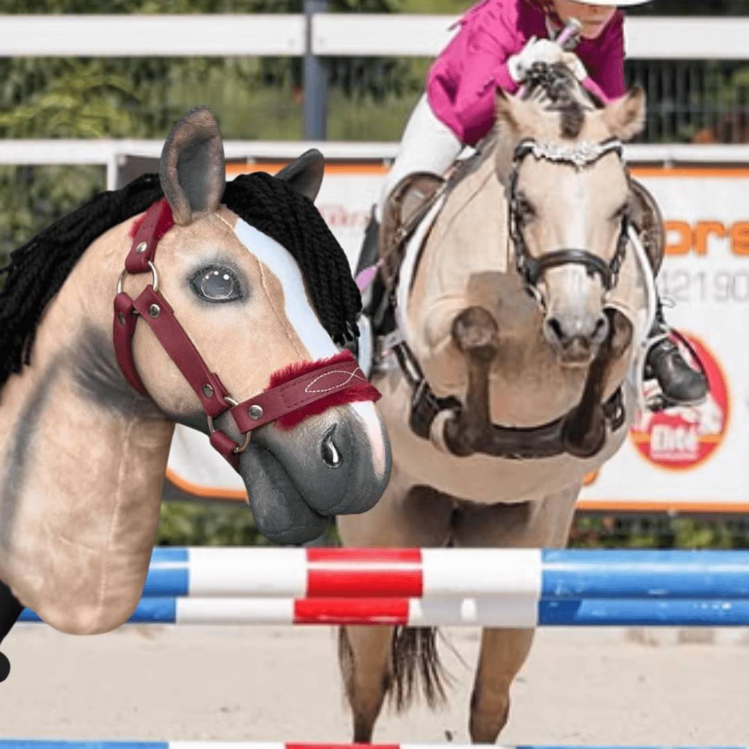 Osoba v růžovém tričku skáče při soutěži přes červeno-bílo-modrou překážku s personalizovaným „Hobby Horse Koník podle fotografie“ od Hobby Horse LarDen. V popředí je detailní záběr hlavy tohoto zakázkového koníka.