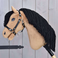 Hobby Horse Samantha s černou ohlávkou od Hobby Horse LarDen má béžový obličej, černou přízovou hřívu, vyšívané detaily a černou ohlávku, na světlém dřevěném pozadí.