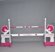 Překážka LarDen kolmák 110 cm od Hobby Horse LarDen s růžovými a bílými tyčemi, siluetami koňských hlav a nastavitelnou výškou — ideální pro jízdu na Hobby Horse. Značka: Hobby Horse LarDen. Na jednobarevném šedém pozadí.
