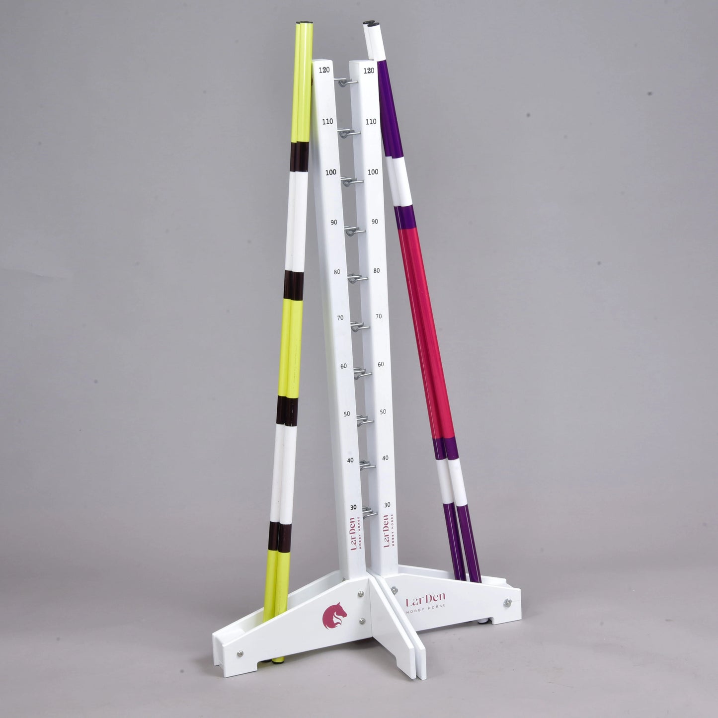 Set překážek pro Hobby Horsing od Hobby Horse LarDen obsahuje bílé stojany s vyznačenými výškovými stupni a dvě pruhované tyče – ideální pro nastavitelné agility nebo skoková cvičení.