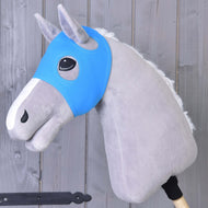 Šedý plyšový Hobby Horse od Hobby Horse LarDen má nasazenou modrou Masku bez uší Sky zakrývající oči, je nasazený na dřevěné tyči a umístěný na pozadí dřevěných prken.