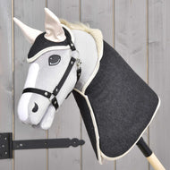Set Blue Denim od Hobby Horse LarDen s ručně vyráběným Hobby Horse s hlavou z modrého denimu a dřevěnou tyčí vytváří půvabnou dekoraci, která vyniká před pozadím ze světlých dřevěných panelů.