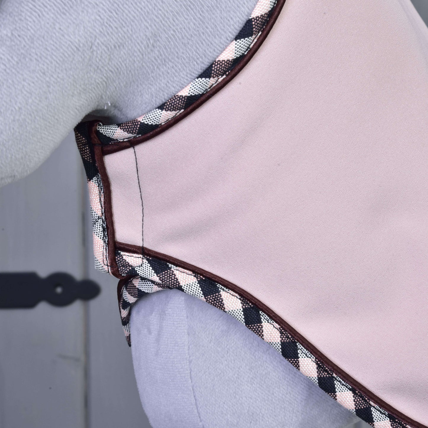 Detail Set Abby od Hobby Horse LarDen – světle růžový doplněk s černým, bílým a růžovým kostkovaným lemováním, podobný čabrace na uši – nošený na světlém pozadí, vlevo je viditelný ozdobný pant.