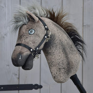 Hobby Horse Bolero s černou ohlávkou - velikost S od Hobby Horse LarDen, s hnědě skvrnitou hlavou Appaloosy, černou ohlávkou, knoflíkovýma očima a nadýchanou vícebarevnou hřívou, vyfotografovaný na dřevěném pozadí.