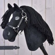 Hobby Horse Cloony s černou ohlávkou od Hobby Horse LarDen, černý plyšový model inspirovaný hřebcem American Quarter Horse, s bílou skvrnou u oka, černou přízovou hřívou a černou ohlávkou, na světlém dřevěném pozadí.