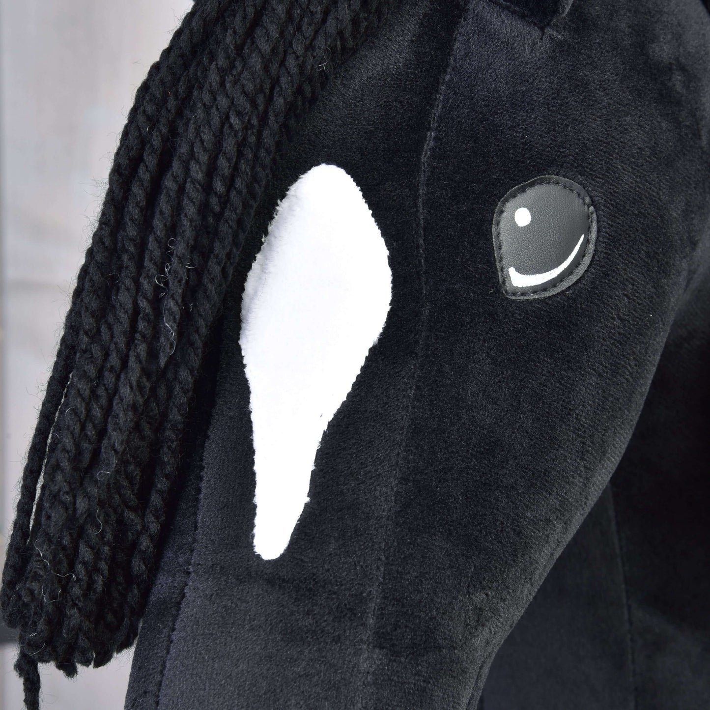 Detail Hobby Horse Cloony s černou ohlávkou od Hobby Horse LarDen, černý plyšový Hobby Horse s bílou skvrnou na hlavě, černou přízovou hřívou a vyšívaným okem s bílým odleskem.