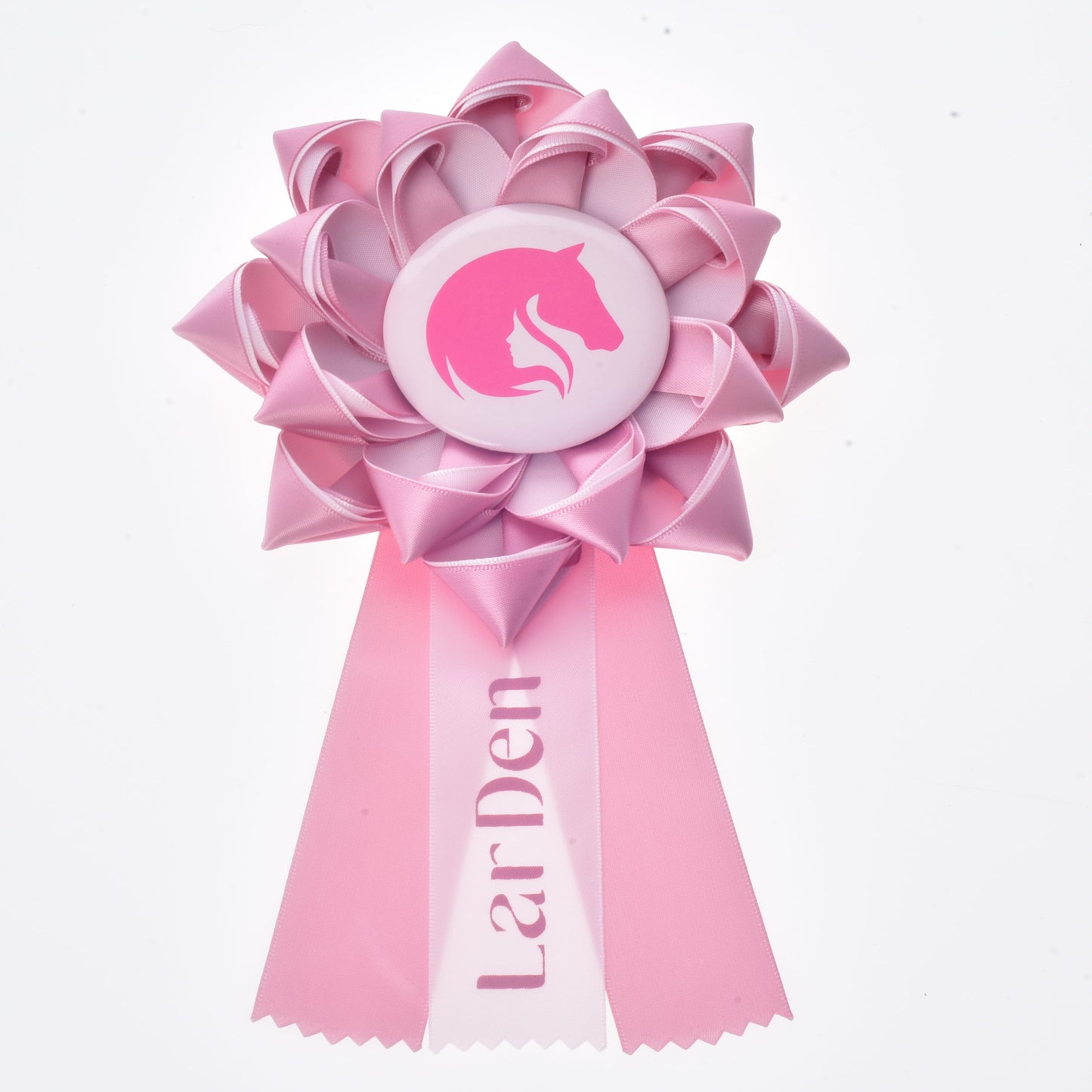 Hobby Horse Kokarda LarDen Pink od Hobby Horse LarDen, růžová výstavní kokarda pro koně se siluetou koňské hlavy uprostřed a dvěma stuhovými cípy, s nápisem "LarDen" na jednom z cípů.