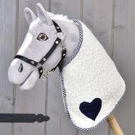 Deka Cube Blue od Hobby Horse LarDen na plyšovém Hobby Horse se šedým obličejem, černou uzdečkou a dekou s modrým akcentem, nasazeném na dřevěné tyči, na dřevěném pozadí.