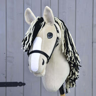 Hobby Horse Aurora s černou ohlávkou od Hobby Horse LarDen, s béžovým plyšovým provedením inspirovaným American Quarter Horse, černou ohlávkou, černo-bílou přízovou hřívou, bílým plstěným pruhem na nose a na dřevěné tyči před světle šedou dřevěnou stěnou.