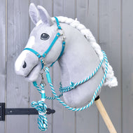 Set Start Tyrkys (ohlávka + nákrčník + vodítko + otěže) od Hobby Horse LarDen na šedém plyšovém Hobby Horse s bílou hřívou, zobrazeném na šedém dřevěném pozadí.
