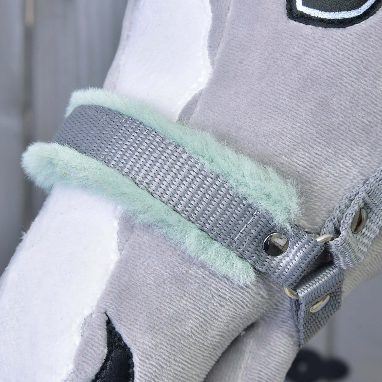Detailní záběr hlavy šedobílého plyšového koně s Hobby Horse LarDen Ohlávkou šedou s mint beránkem, s měkkou mint podšívkou z umělé kožešiny, kovovými nýty a detailním prošitím – půvabný doplněk pro Hobby Horse.