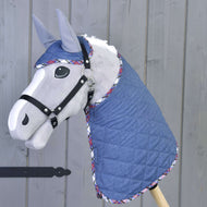 Set Jeans od Hobby Horse LarDen, šedý kůň s modrou prošívanou dekou a ladící čabrakou s kostkovaným lemem, vše nasazené na dřevěné tyči na pozadí šedého dřeva.