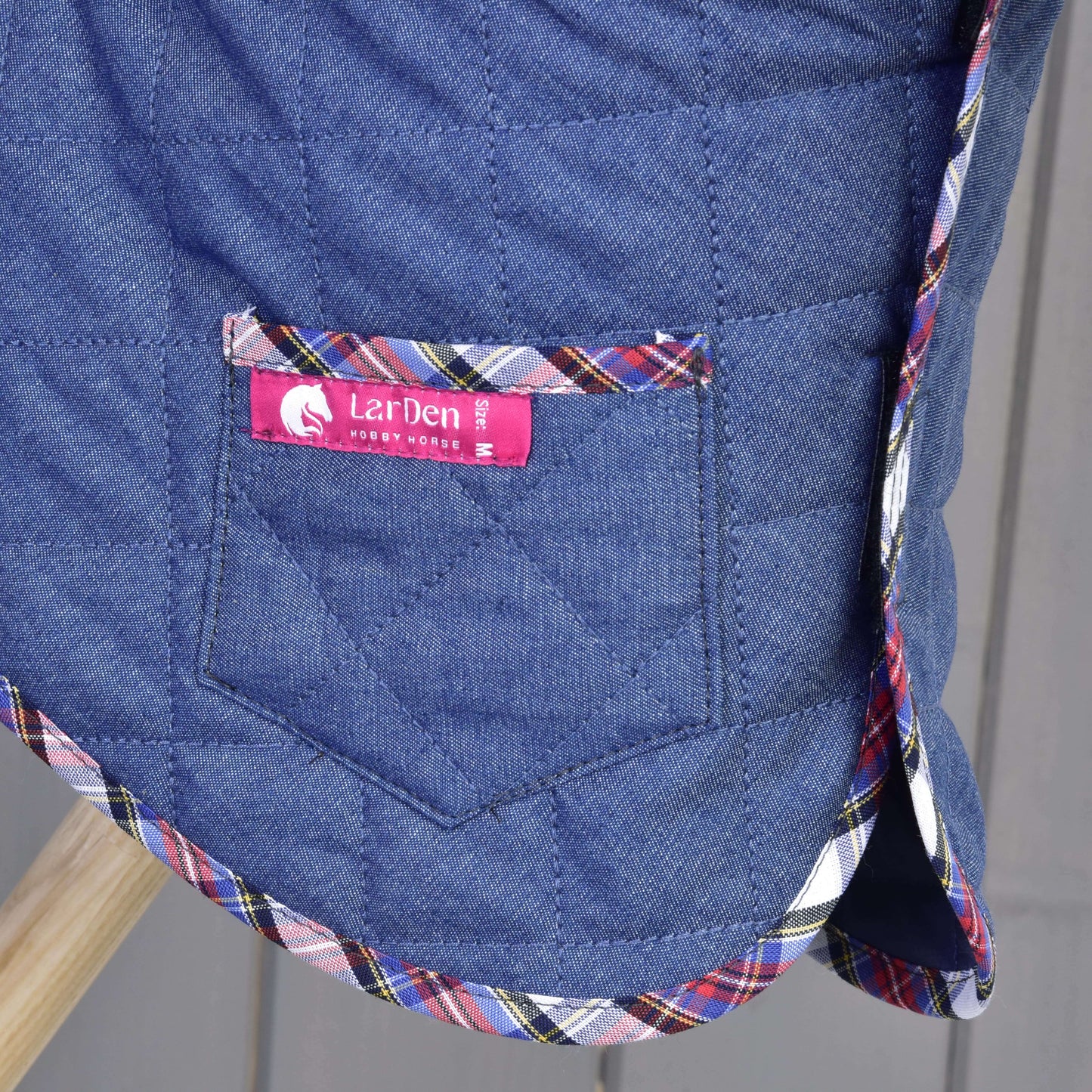 Detail Set Jeans, modré prošívané deky od Hobby Horse LarDen, s kapsou, vícebarevným kostkovaným lemem a růžovým štítkem s nápisem Hobby Horse LarDen.