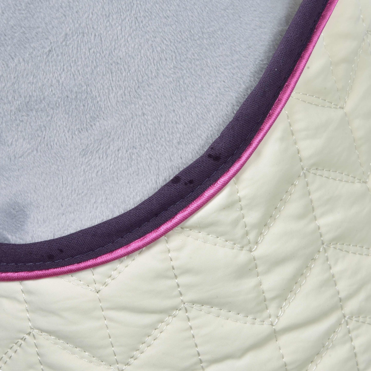 Detail Set Supreme Crema od Hobby Horse LarDen: prošívaná látka s geometrickým vzorem šití, lemovaná tmavě fialovým a růžovým lemem a podšitá měkkým světle šedým materiálem.