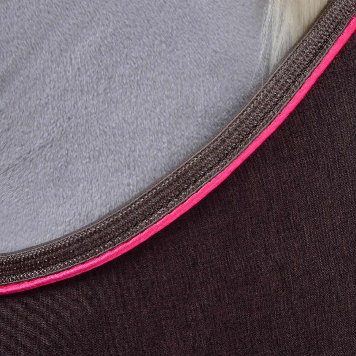 Detail hnědé látky deky pro Hobby Horse s jasně růžovým a hnědým lemováním okrajů
