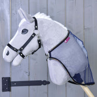 Šedý plyšový Hobby Horse LarDen s černou uzdečkou a připevněnou dekou proti hmyzu LarDen, zobrazený před světle šedými dřevěnými dveřmi s černým pantem.