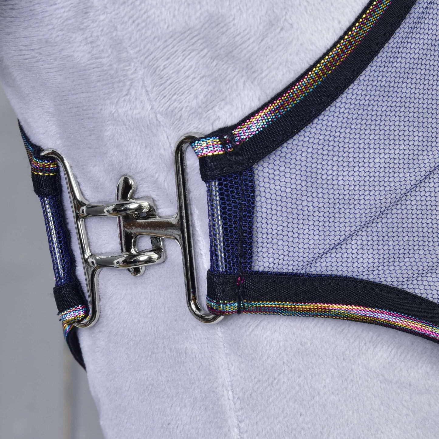 Detail lesklé kovové spony spojující dva díly síťoviny z PES s tmavými okraji a duhovým lemováním na dece proti hmyzu LarDen od Hobby Horse LarDen, zobrazené na bílém pozadí.