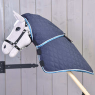 Deka s odepínatelným krkem Mandarin od Hobby Horse LarDen v prošívané modré se světle modrým lemováním, zobrazená na šedém Hobby Horse s uzdečkou na pozadí dřevěných prken.