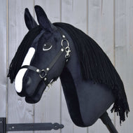 Hobby Horse Freya s černou ohlávkou od Hobby Horse LarDen má černou látku, bílý nosní pruh a dlouhou černou přízovou hřívu inspirovanou plemenem Irish Cob, zobrazená na světlém dřevěném pozadí.