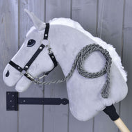 Hobby Horse - pletené vodítko Graphite od Hobby Horse LarDen se šedou plyšovou hlavou, černou uzdečkou a ručně pleteným grafitovým vodítkem na dřevěné tyči, zobrazené před šedou dřevěnou stěnou.