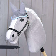 Čabraka háčkovaná šedá od Hobby Horse LarDen na plyšovém šedém Hobby Horse s bílou hřívou a černou uzdou, nasazeném na dřevěné tyči před světlou dřevěnou stěnou.