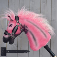 Limitovaná edice Hobby Horse LarDen Pinkie s třpytivou ohlávkou od Hobby Horse LarDen, nasazená na tyči a umístěná před šedou dřevěnou stěnou.