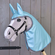 Šedý Hobby Horse od Hobby Horse LarDen s černou uzdečkou, velkýma plstěnýma očima a kapucí Pláštěnka Light Blue s ladícíma ušima, zobrazený před dřevěnou stěnou.