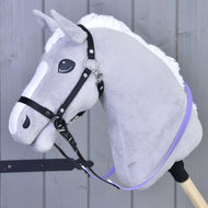 Otěže pogumované Light purple od Hobby Horse LarDen na šedém plyšovém Hobby Horse s bílou hřívou a bezudidlovou uzdečkou, nasazeném na dřevěné tyči před obloženým dřevěným pozadím.