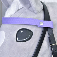 Detail hlavy plyšové hračky Hobby Horse LarDen s Kompletní uzdečkou bez nánosníku Light Purple, která má fialový řemínek s šestiúhelníkovým vzorem, kovový druk a odnímatelné otěže na šedé a bílé srsti.