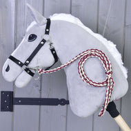 Hobby Horse - pletené vodítko Maroon od Hobby Horse LarDen se šedou plstěnou hlavou, černou uzdečkou a ručně pleteným vínovo-bílým vodítkem, nasazené na dřevěné tyči před šedou dřevěnou stěnou.