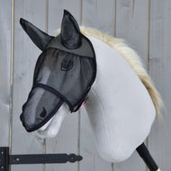 Maska proti hmyzu de Luxe Full od Hobby Horse LarDen na bílém Hobby Horse se světlou hřívou, jehož obličej chrání černá síťovina, na dřevěném pozadí.