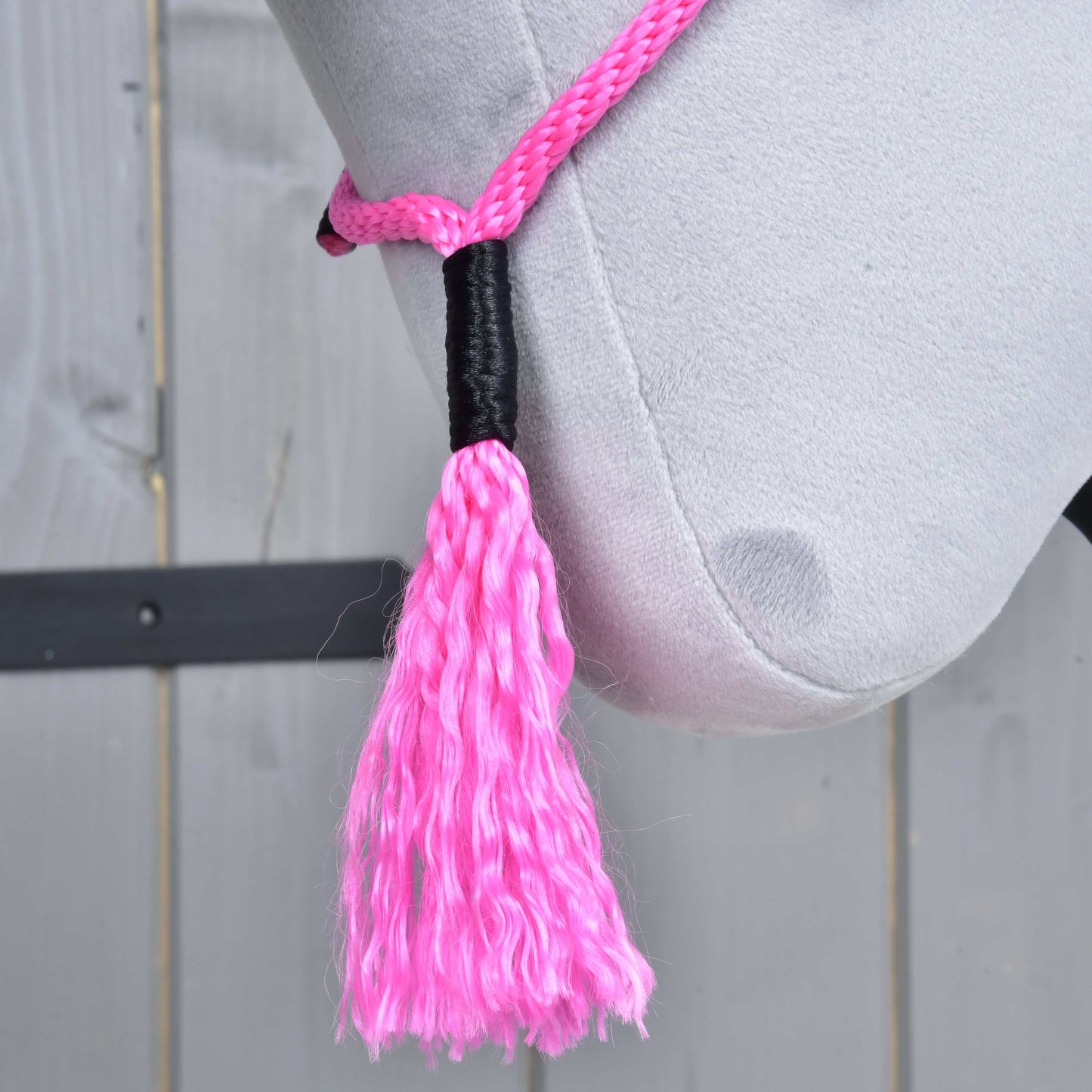 Detail Hobby Horse LarDen „Nákrčník Pink Festive“ – hlava světle šedého plyšového koně s růžovým lanovým ohlávkou a střapcem na dřevěném pozadí. Ideální pro fanoušky hobby horse cordea nebo ježdění bez uzdečky.