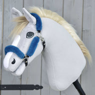 Hobby Horse LarDen Ohlávka s beránkem Teddy Petrol na plyšovém Hobby Horse se světle šedou látkou, bílým mulem, blond hřívou a modrou koženkovou ohlávkou na černé tyči, před dřevěným pozadím.