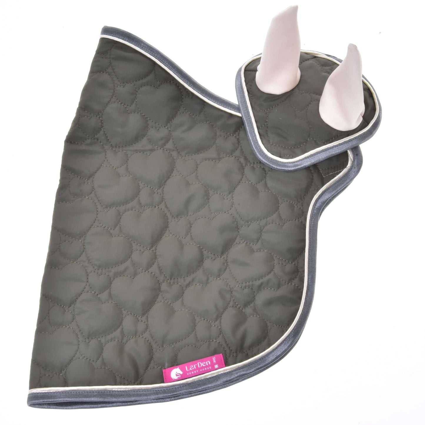 Set Olivetti od Hobby Horse LarDen obsahuje zelenou prošívanou čabraku a ladící podsedlovou dečku se šedým lemováním a bílou vnitřní podšívkou uší, zobrazené na bílém pozadí. K podsedlové dečce je připevněný růžový štítek – ideální do vaší sbírky.