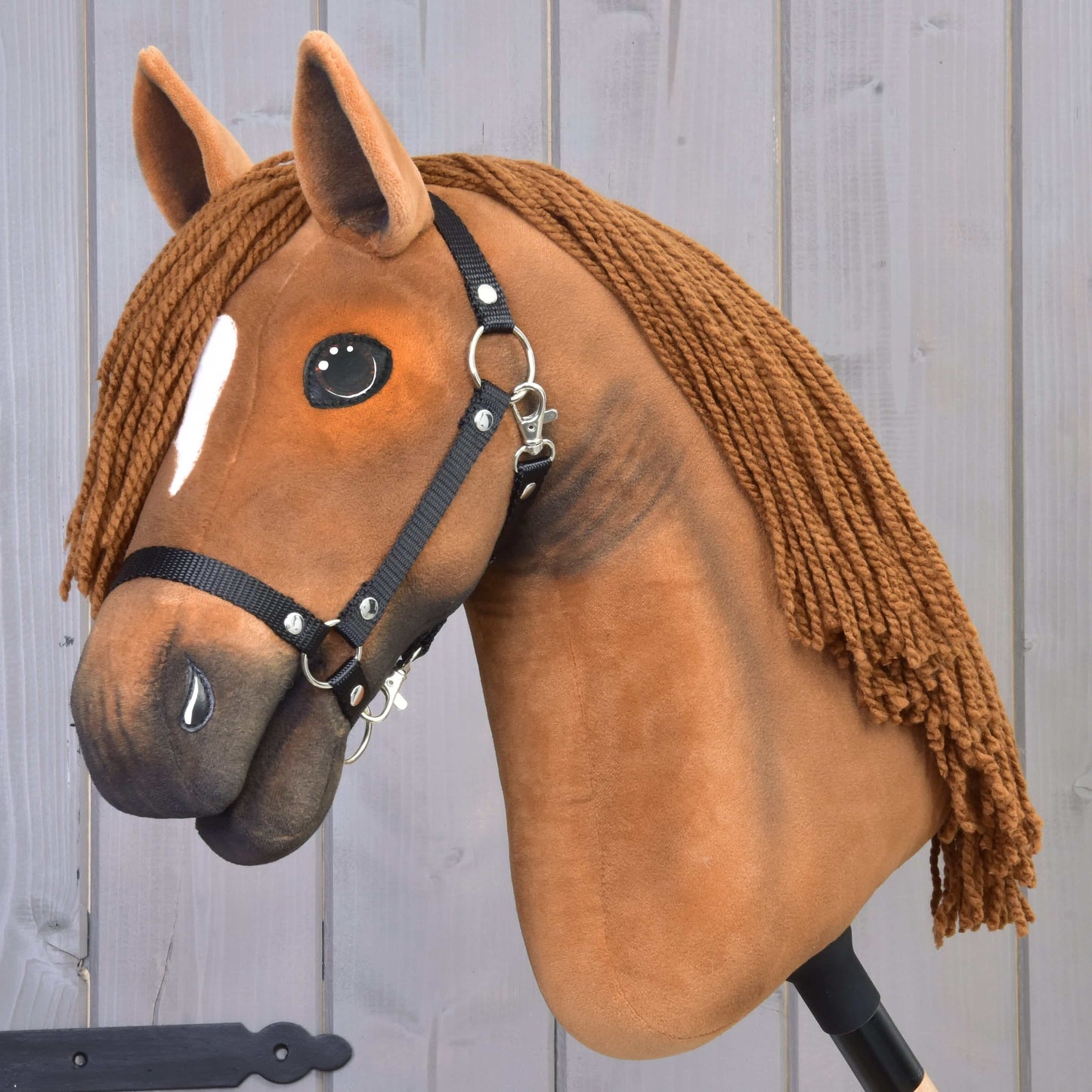 Hobby Horse Pippa s černou ohlávkou od Hobby Horse LarDen s designem kaštanové klisny, hnědou přízovou hřívou, bílou skvrnou na čele a černou ohlávkou, nasazený na tyči – ideální pro drezurní hru.