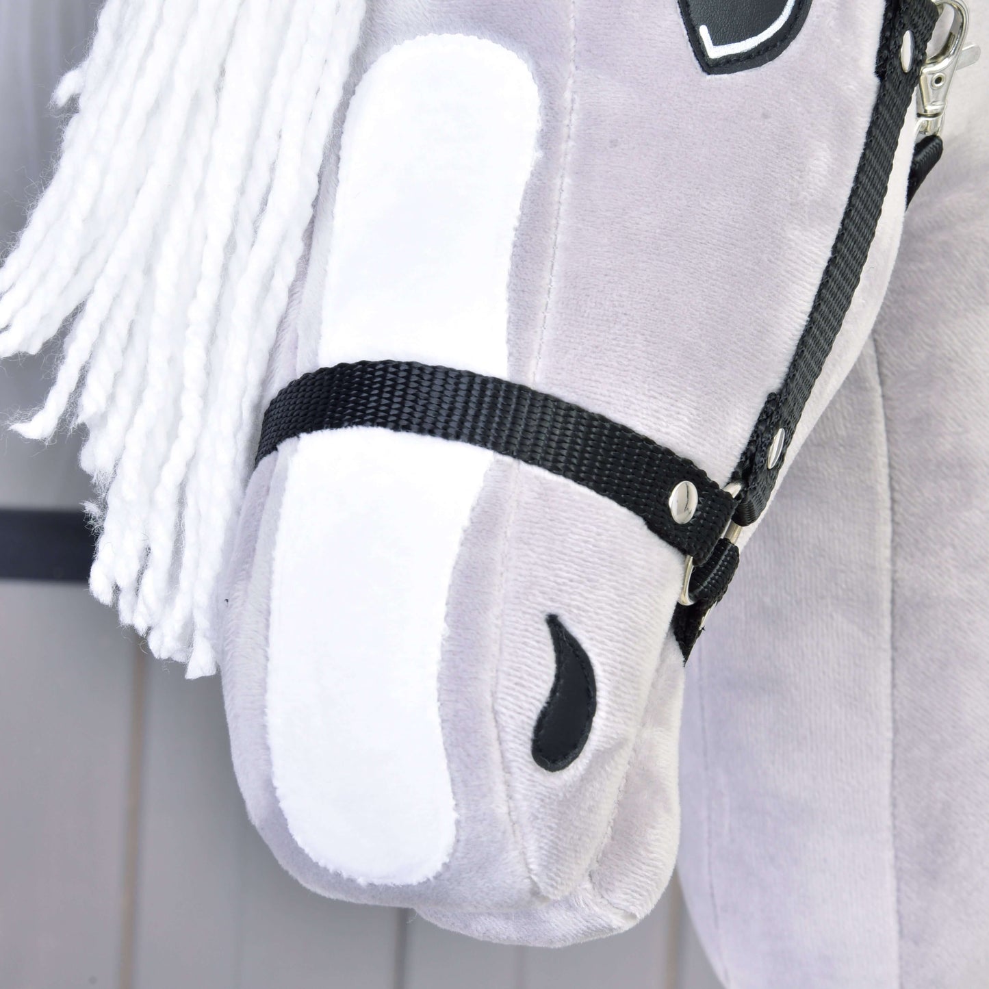 Detail šedého plyšového Hobby Horse Popcorn s černou ohlávkou od Hobby Horse LarDen, inspirovaného anglickým plnokrevníkem, s bílou přízovou hřívou, černou ohlávkou a jemnými šitými detaily včetně černé nozdry.