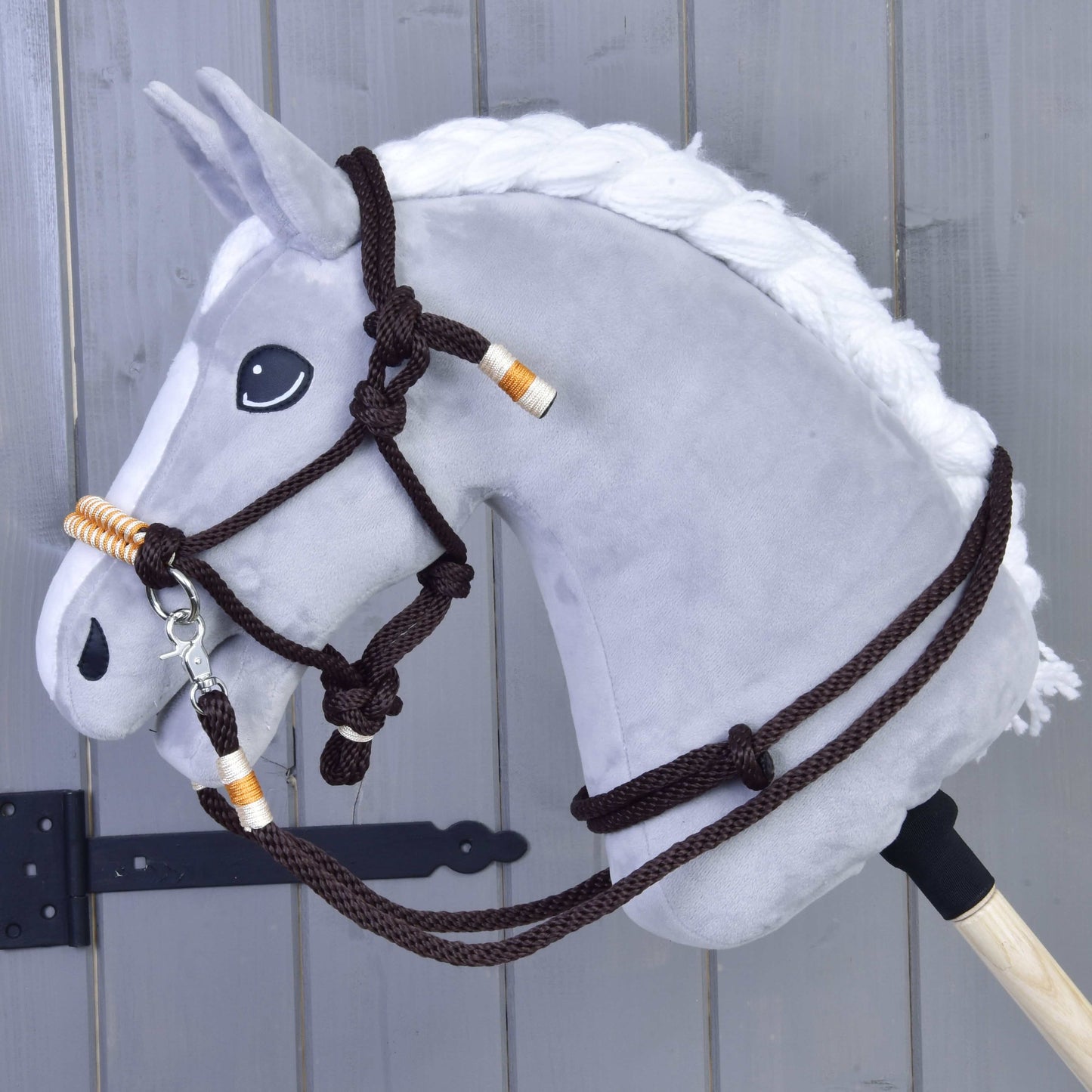 Provazový set Orange od Hobby Horse LarDen je zobrazený před dřevěným plotem, s oranžovým provazovým setem bezpečně připevněným k pevné dřevěné tyči.