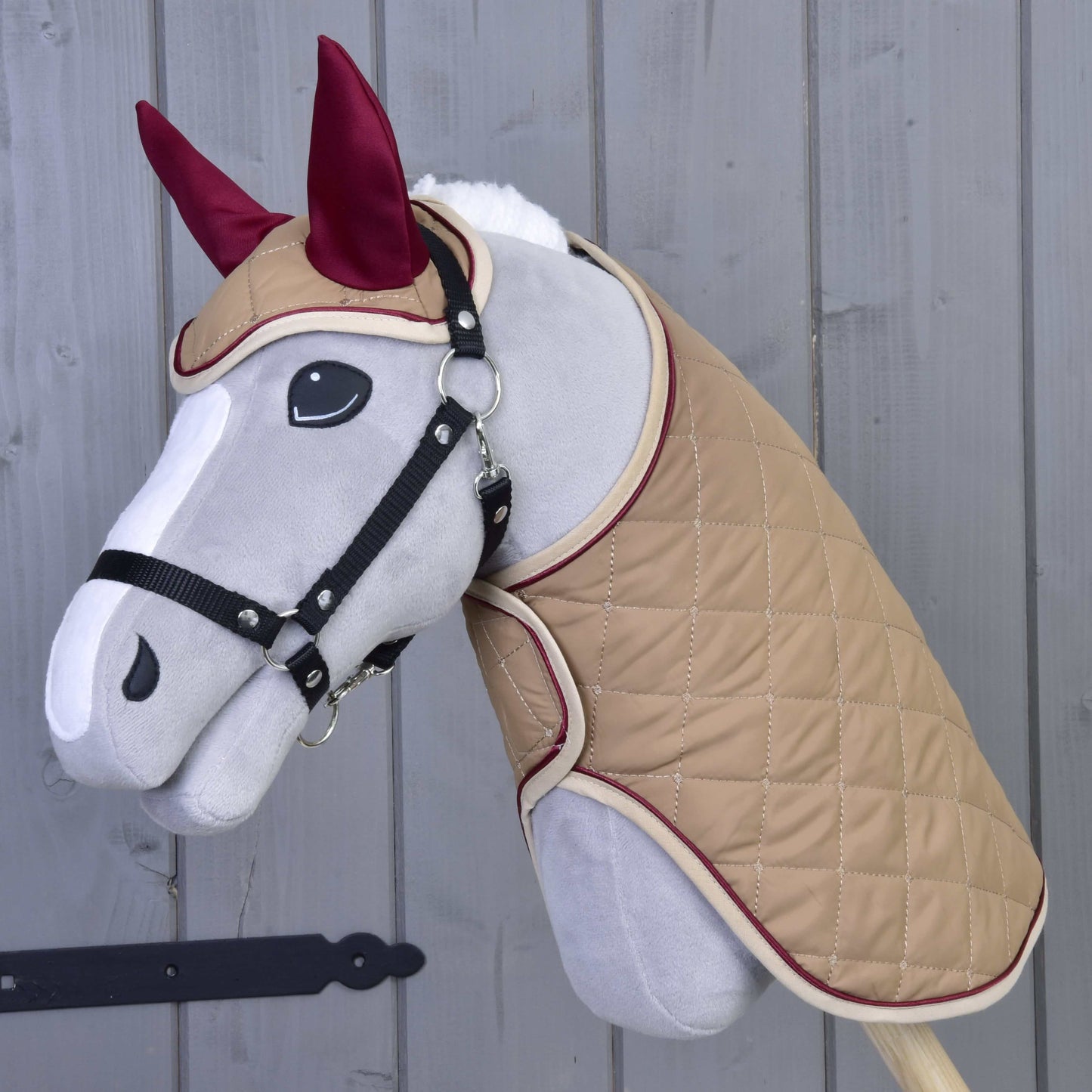 Set Roma od Hobby Horse LarDen je plyšový Hobby Horse se světle šedým obličejem, černou uzdečkou, béžovým prošívaným pláštěm a vínovou čabrakou – ideální pro nápaditou hru nebo ke kombinaci s dekovou sadou.