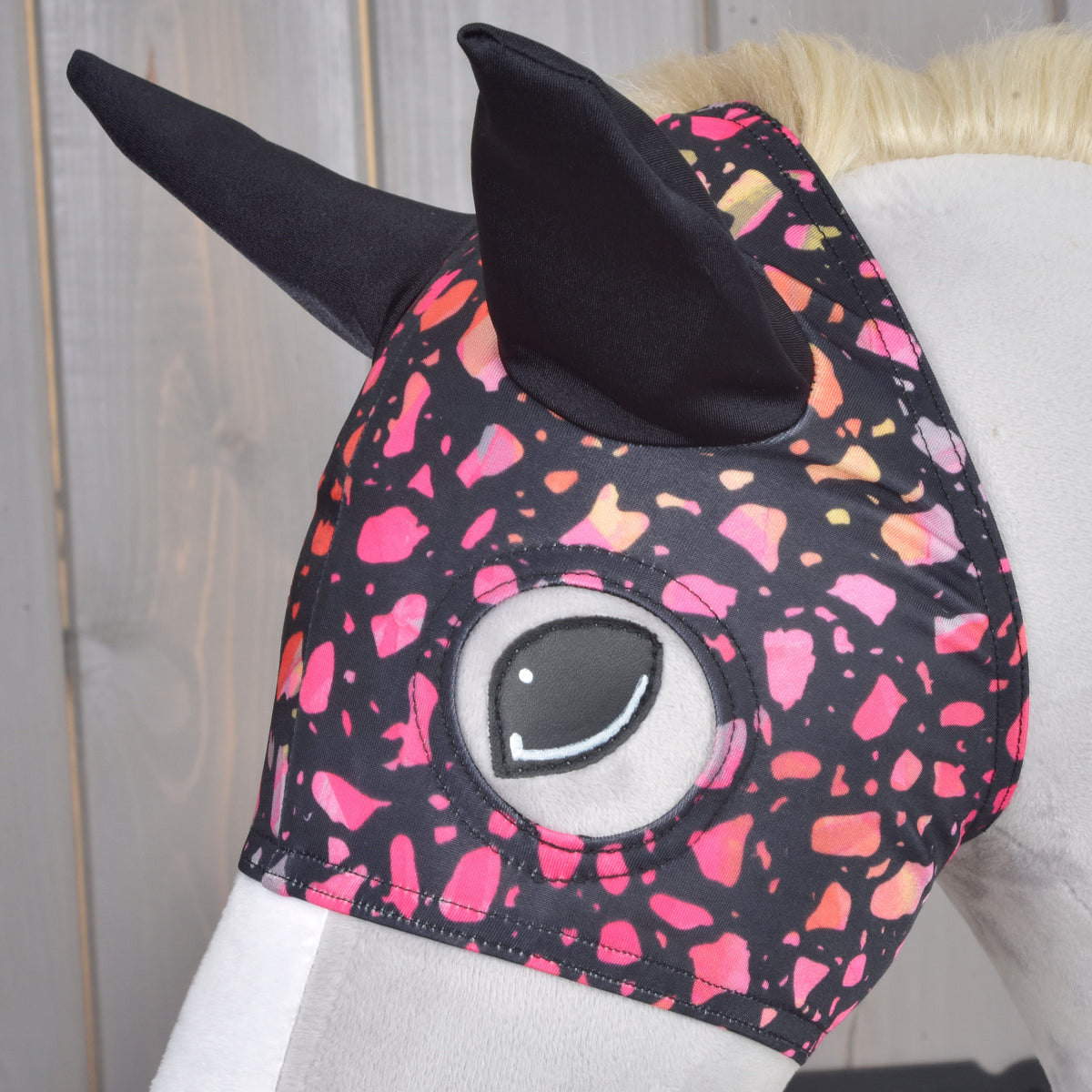 Close-up of Horse Mask Roxy worn on a grey Hobby Horse, showing the colourful black lycra pattern