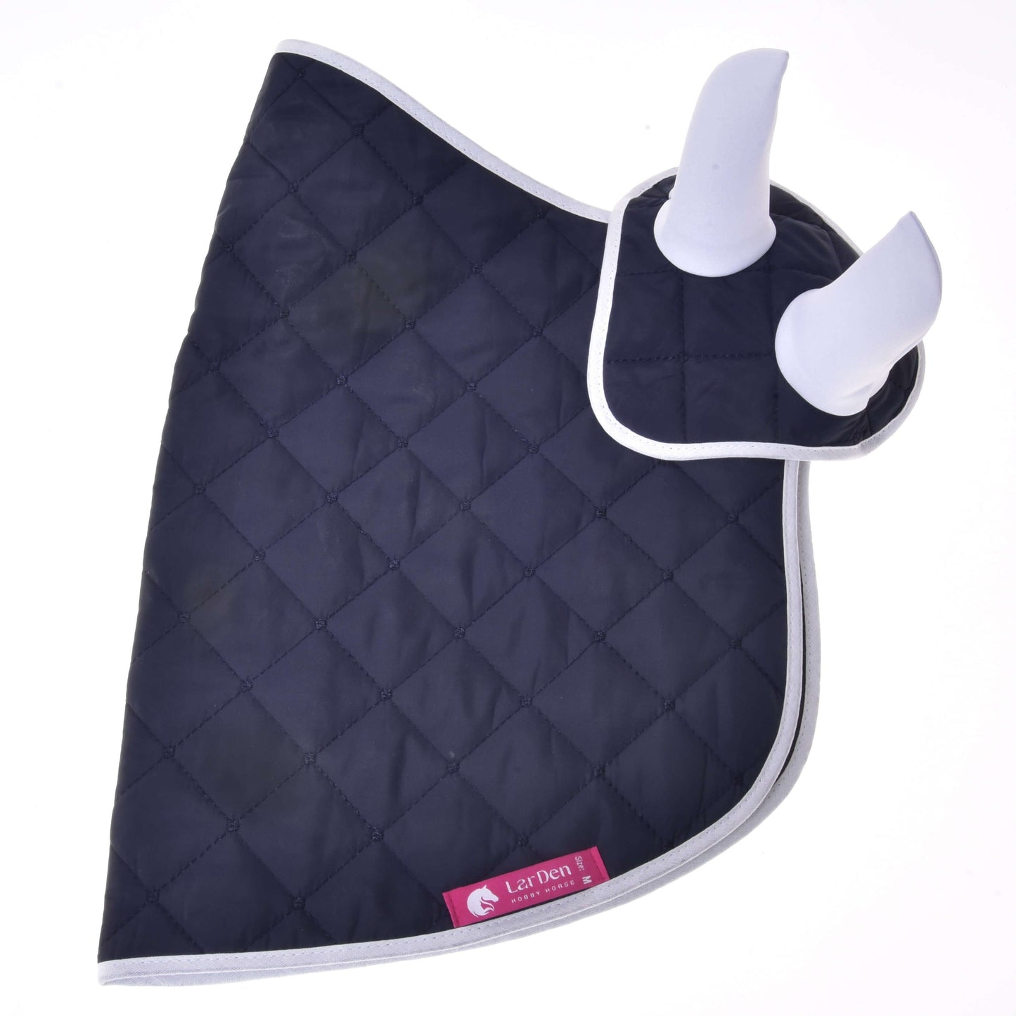Set Monte od Hobby Horse LarDen je tmavě modrá prošívaná deka se světle šedým lemováním a dvěma bílými polstrovanými kryty uší, tvořící stylovou sadu čabraky na uši. Růžový štítek s logem koně dodává vzhledu vašeho koně další dekoraci.