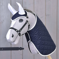 Set Monte od Hobby Horse LarDen tvoří šedá plyšová hlava Hobby Horse s tmavě modrou prošívanou dekou a ladící sadou čabraky na uši s bílým lemováním, zobrazená na tyči před světlým dřevem – ideální dekorativní kousek.