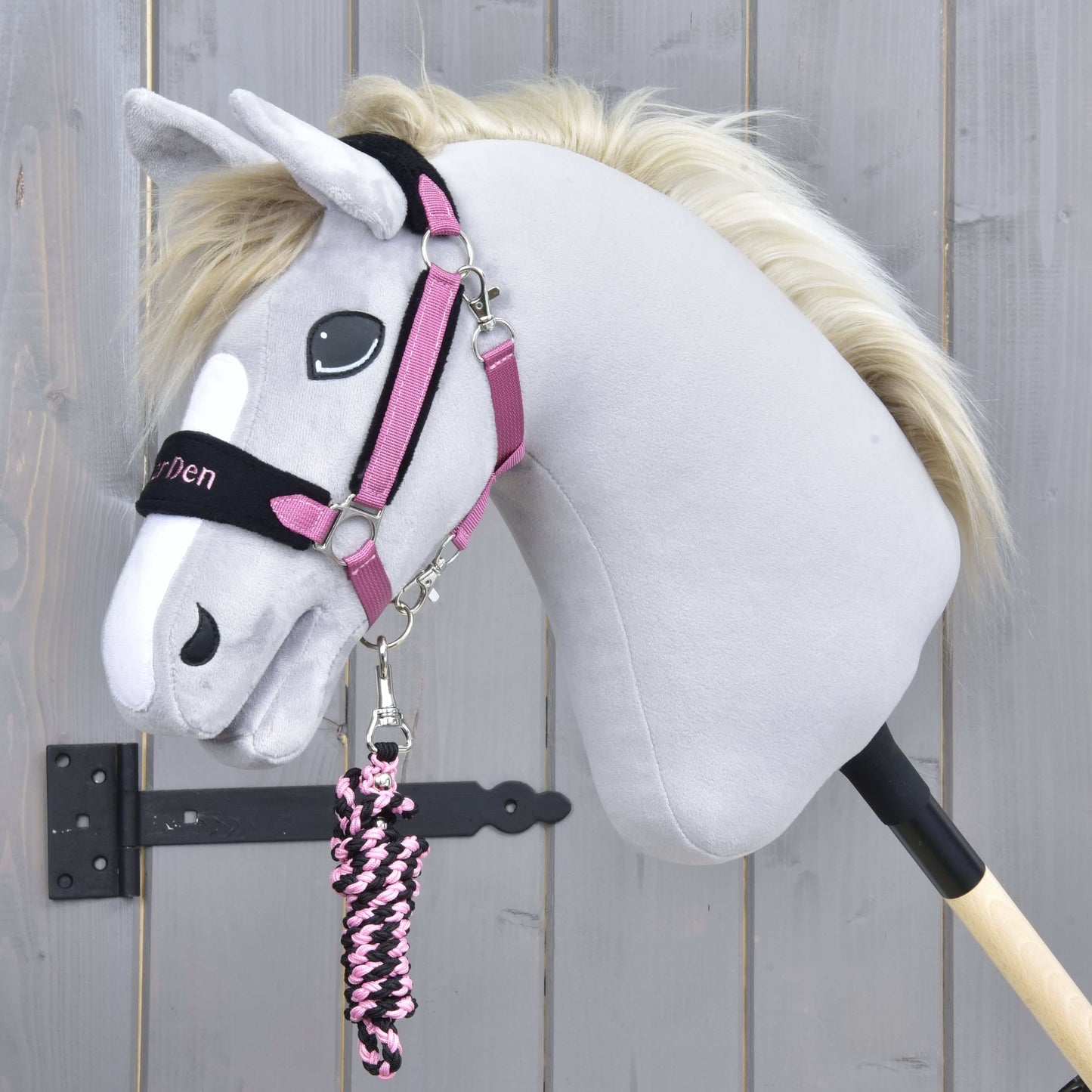 Set LarDen Exclusive Pink od Hobby Horse LarDen, šedý Hobby Horse s bílou lysinou, huňatou hřívou, očima v kresleném stylu, černo-růžovou ohlávkou s fleecovým nánosníkem a ladícím růžovo-černým vodítkem na tyči.