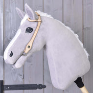 Uzdečka western jednouška od Hobby Horse LarDen na šedém plyšovém koni na dřevěné tyči, s prémiovou koženou westernovou uzdečkou one-ear, na pozadí stěny z dřevěných prken.