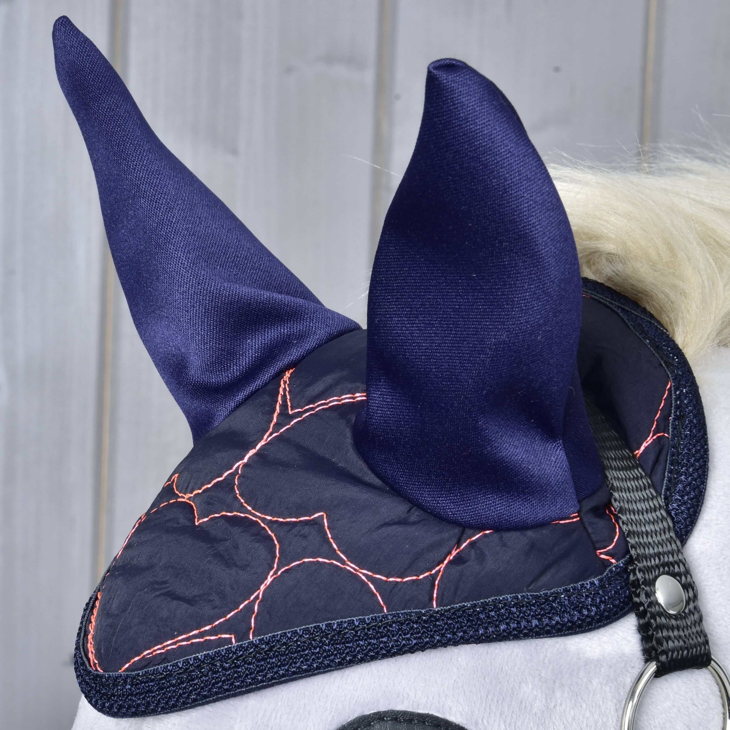 Detail koně s čabrakou Čabraka Pink Heart od Hobby Horse LarDen pro stylovou ochranu proti hmyzu, s růžovými srdíčkovými motivy a černým páskem, na světlém dřevěném pozadí.
